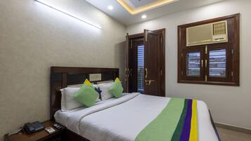 Una camera da letto ordinata con un letto, un comodino e una finestra con cornice in legno.