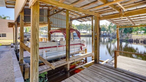 Un barco amarrado en un muelle de madera con una zona techada.