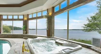 Stunning waterfront villa with indoor pool and kids swing set and play area.