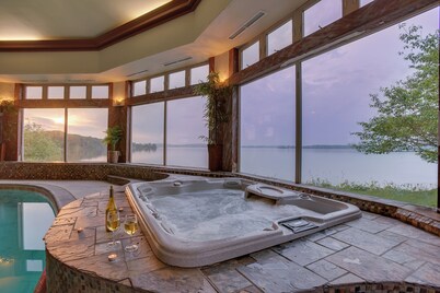 Stunning waterfront villa with indoor pool and kids swing set and play area. 