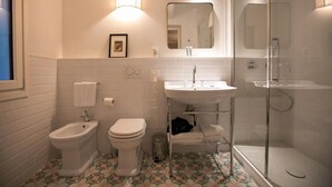 A bathroom with a bidet, toilet, sink, and glass-enclosed shower. - Luxury Apartment with view on Piazza Pitti (Firenze)