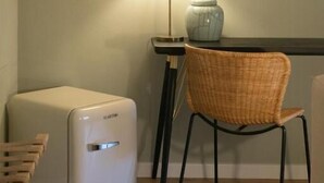 A room with a white radiator, a wicker chair, a lamp, and a framed quote on the wall. - Luxury Apartment with view on Piazza Pitti (Firenze)