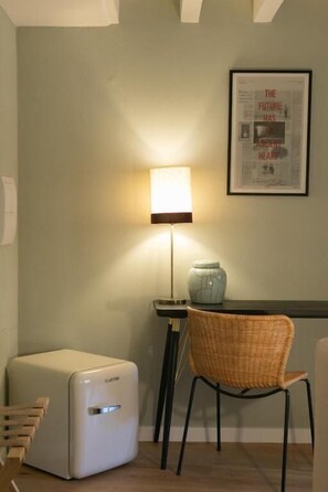 A room with a white radiator, a wicker chair, a lamp, and a framed quote on the wall. - Luxury Apartment with view on Piazza Pitti (Firenze)