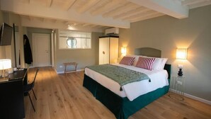 A bedroom with a bed, bedside lamps, a desk, and a chair. - Luxury Apartment with view on Piazza Pitti (Firenze)