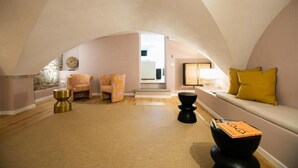 A spacious loft with high ceilings, a cozy seating area with a sofa and chairs, a staircase leading to an upper level, and a large window providing natural light. - Luxury Apartment with view on Piazza Pitti (Firenze)