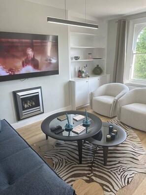 Relax in this stylish living room with a flat-screen TV, comfortable sofa, and decorative coffee table.