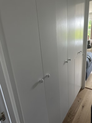 Features a spacious wardrobe with two doors and handles.
