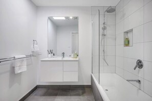 Bathtub, hair dryer, towels, shampoo