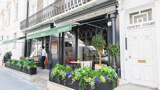 A restaurant with outdoor seating, a sign for 'An Asian Inspired Steakhouse', and a 'CRAVEN COURT' building adjacent to it. - Stylish & cozy City Studio close to Hyde Park - Pass the Keys (London)