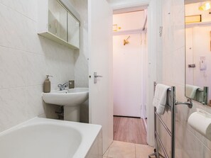 Et moderne badeværelse med badekar, vask og spejl.