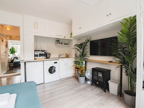 Cozy apartment with a kitchenette, sofa, and flat-screen TV.