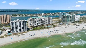 Un complejo hotelero frente al mar con varios edificios altos, una playa y un puerto deportivo.