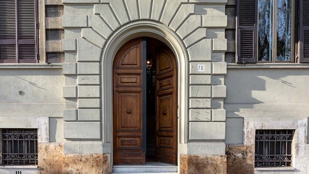 A building with a large wooden door, a stone facade, and a number '78' on the wall. - Trastevere Suites - Top Collection (Rome)
