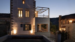 A two-story building with a balcony and a stone facade.