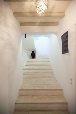A staircase with a modern design, leading to a bright room with a window. - 360 Sunset Villa with Private Pool (Mikonos)