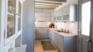 Una cocina moderna con armarios blancos, horno empotrado y una ventana.