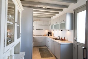 A modern kitchen with white cabinets, a built-in oven, and a window.