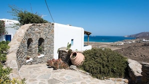 A white building with stone walls and a view of the sea. - Villa Victoria with Sea View and Two Private Pools (Mykonos)