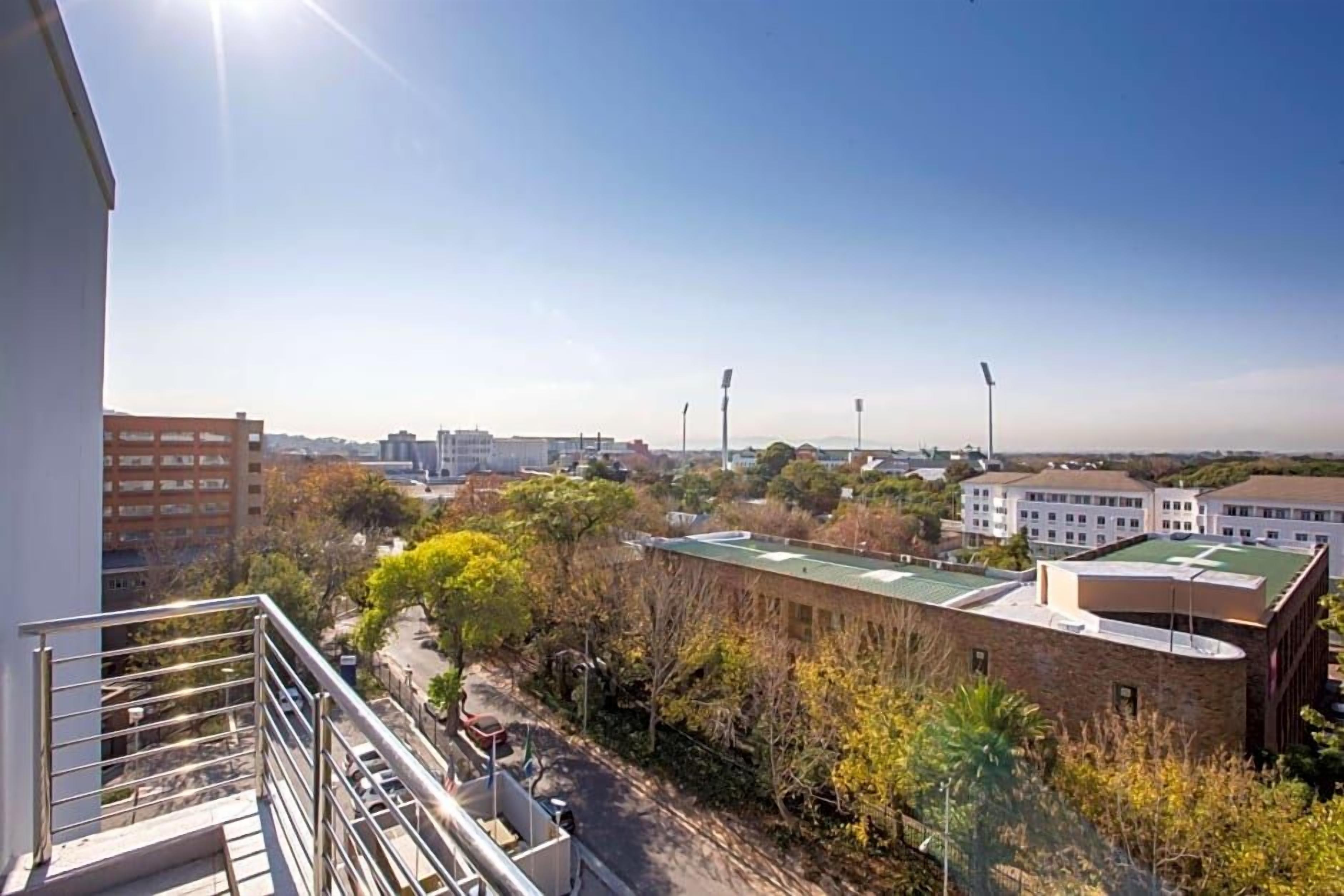 Um edifício alto com vista ampla da paisagem urbana circundante, incluindo outros edifícios e uma rua.