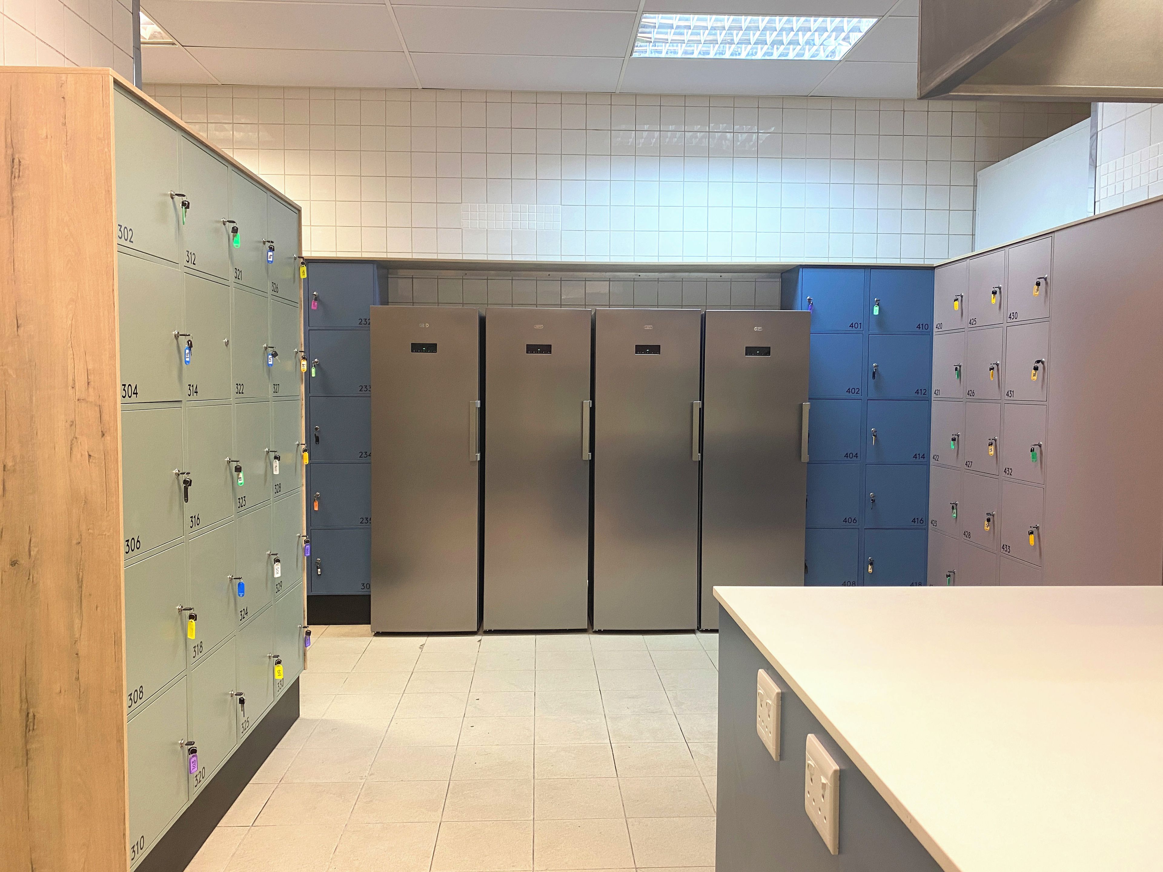 Une chambre d’hôtel avec une kitchenette, un grand miroir et un mur décoratif en bois.