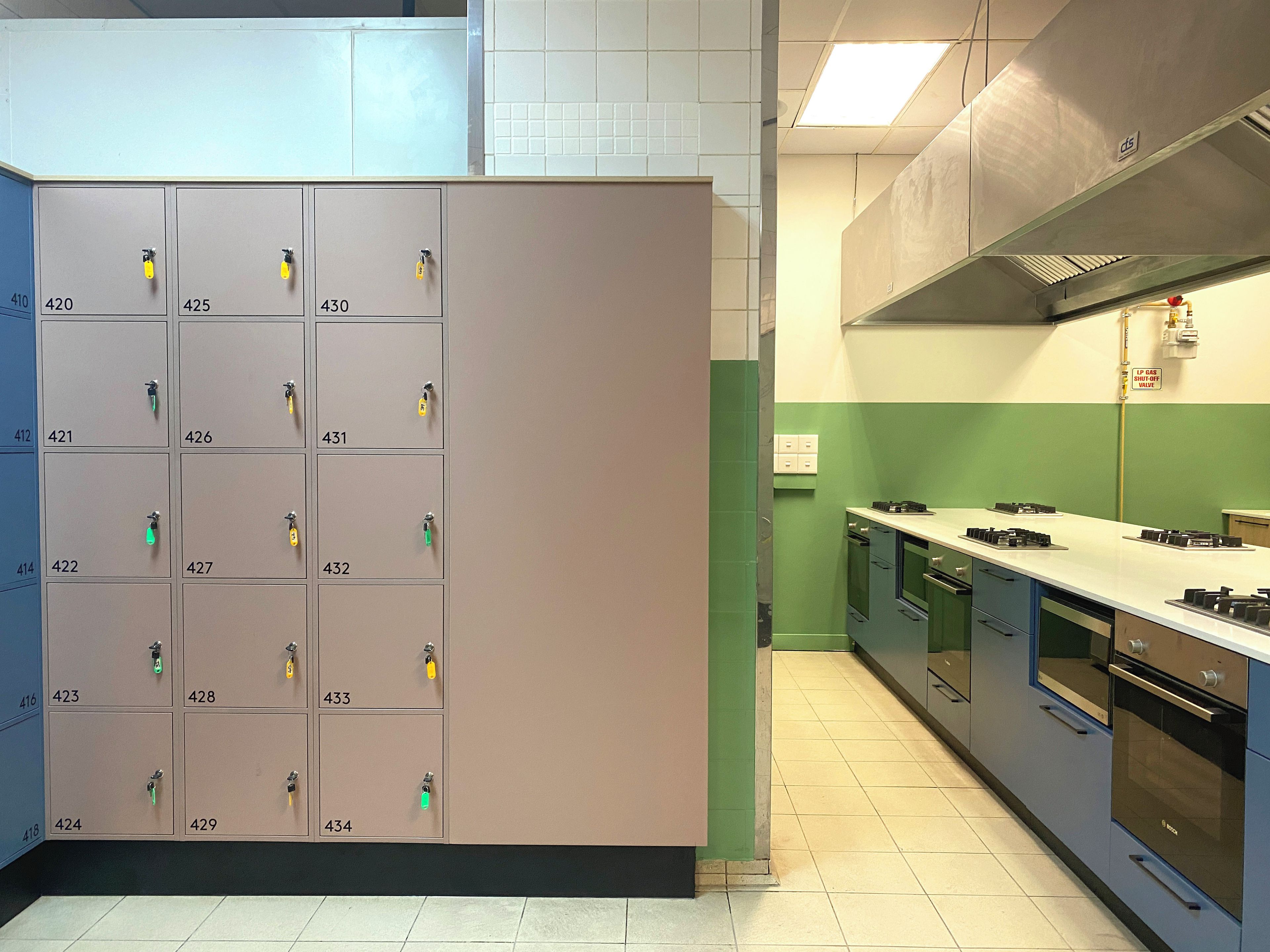 A kitchen with a row of numbered storage cabinets and modern appliances.