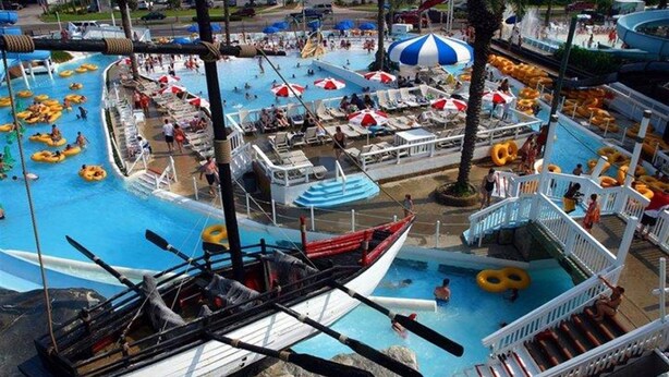Ein Wasserpark mit mehreren Pools, Tretbooten und Liegebereichen.