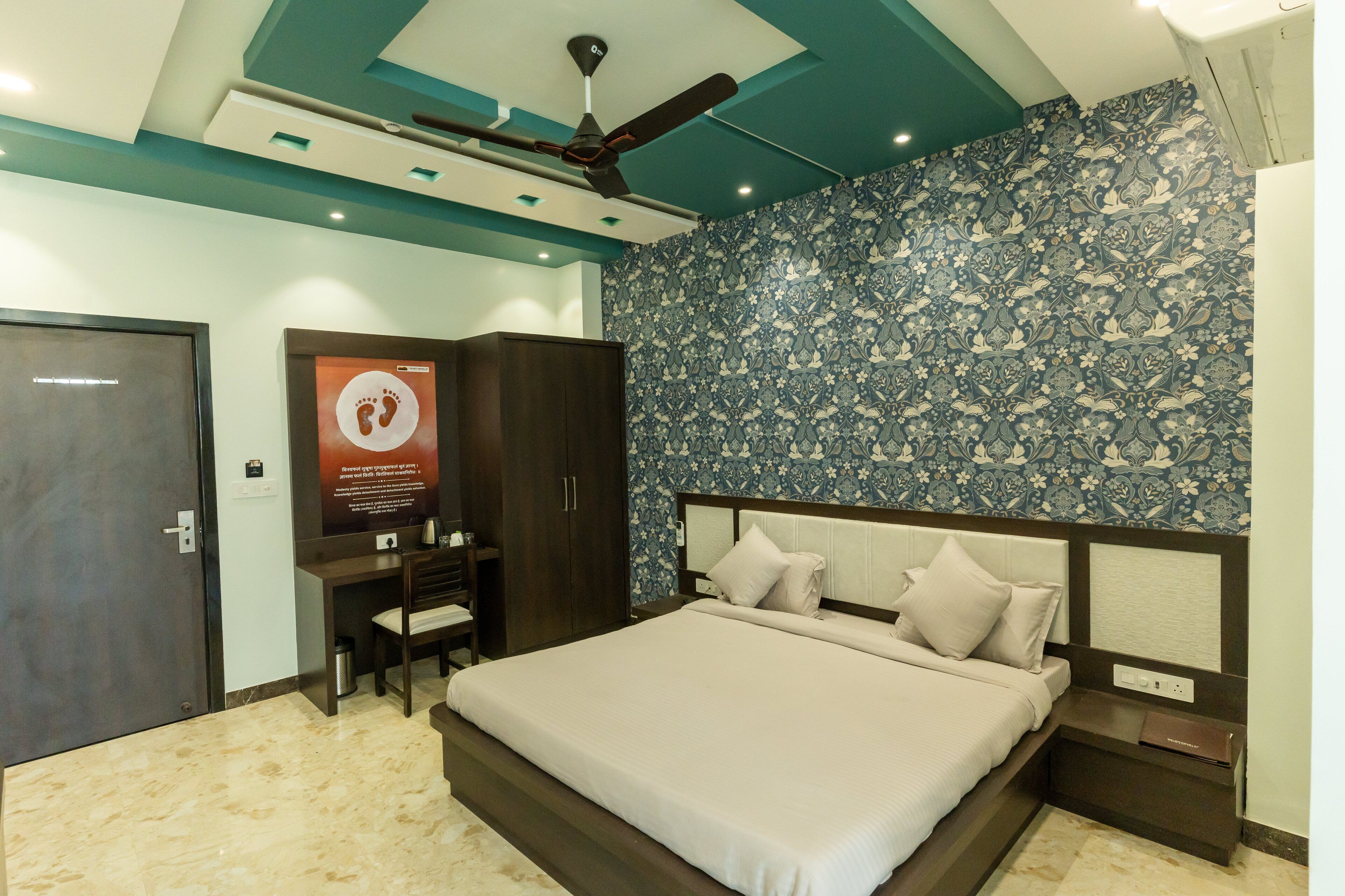 A bedroom with a bed, a desk, and a wardrobe.