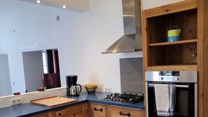 Eine moderne Küche mit Holzausstattung, einem Gasherd und einem eingebauten Backofen.