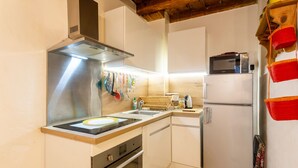 A compact kitchen with a stainless steel range hood, a microwave, and a refrigerator. - L'Observance - Au cœur du centre historique (Arles)