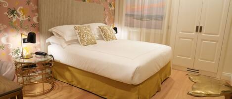A neatly arranged bedroom with a large bed, a bedside table with a lamp, and a wardrobe.