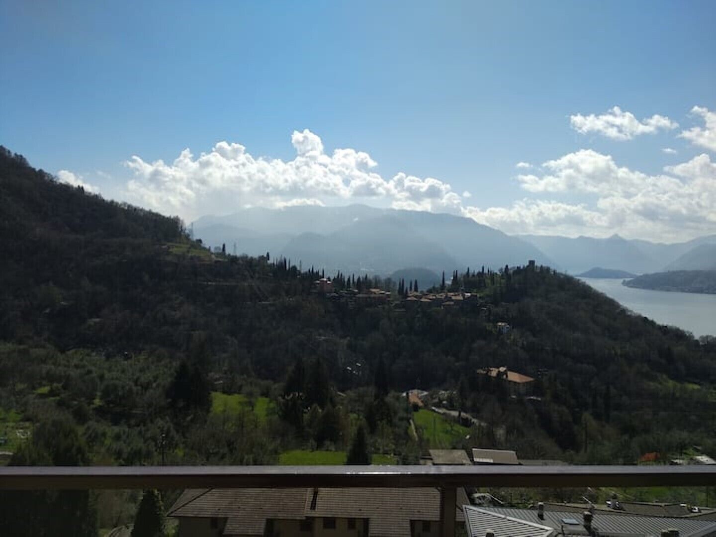 Un paisaje montañoso con un pueblo y un lago.