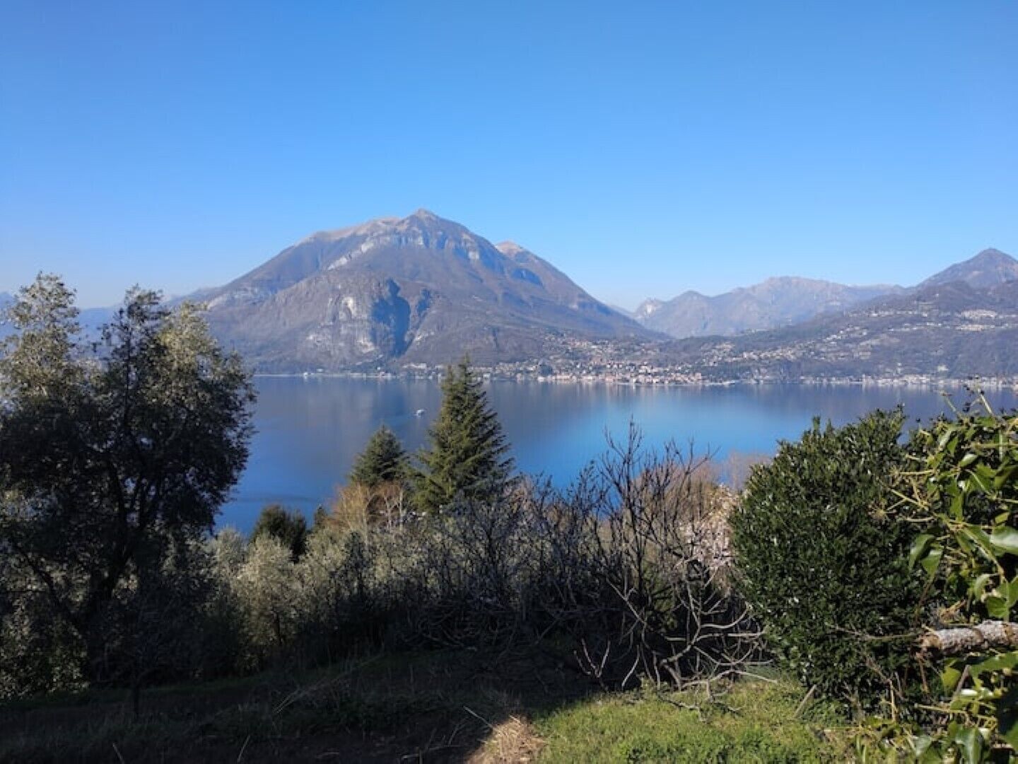 A mountain lake with a clear view of a town in the background.