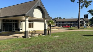 A building with a covered entrance, a parking lot, and a sign for Oakwood Inn. - Oakwood Inn (Oakdale)