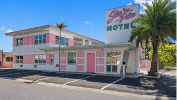 A motel with a retro design, featuring a large sign with neon lettering.