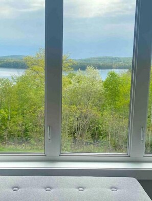 Enjoy a serene view of the lake and surrounding hills from the large window in this peaceful retreat.