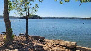 A rocky shoreline with a tree and calm water. - Tiny Getaway at Ten Killer (Vian)