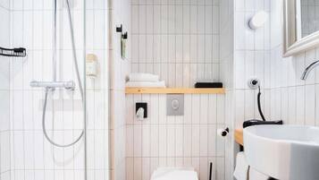 A modern bathroom with a toilet, sink, and shower.