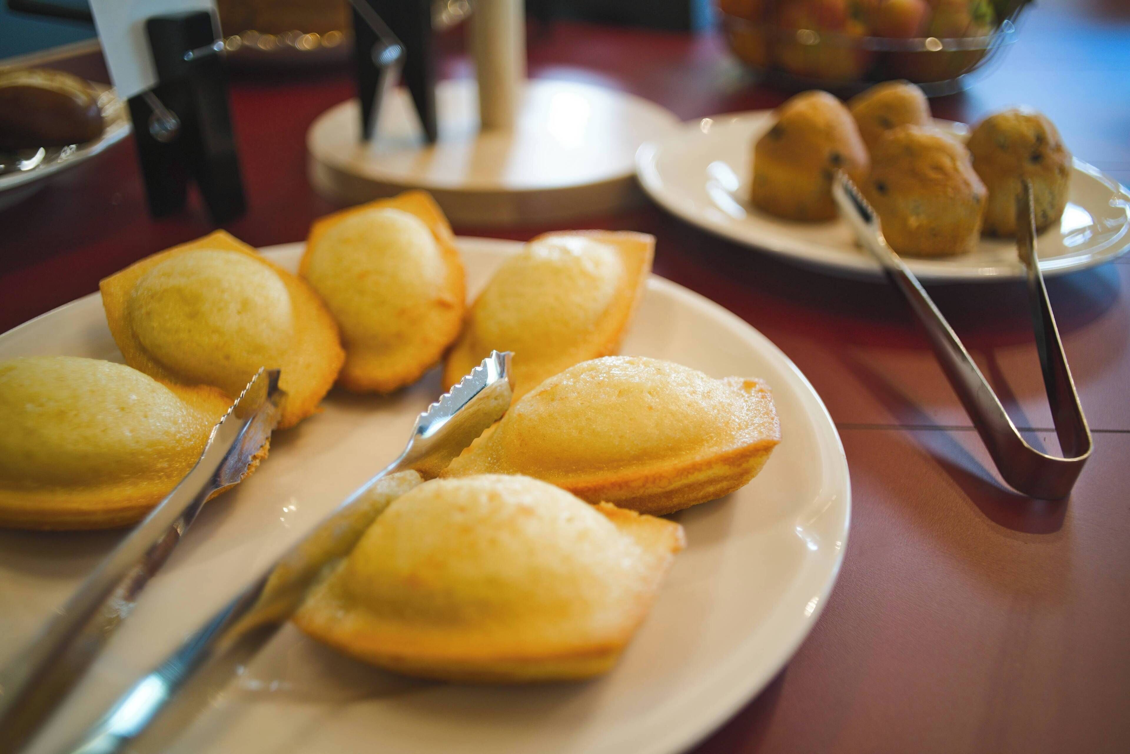 Una mesa con platos de pasteles y un par de pinzas.