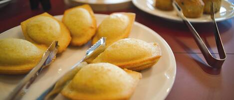 Una mesa con platos de pasteles y un par de pinzas.