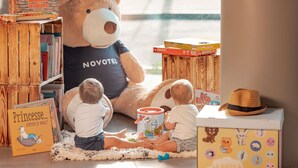 A room with a large teddy bear, children's books, and toys. - Novotel Paris Val de Fontenay (Fontenay-sous-Bois)