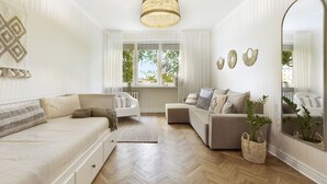 A modern living room with a sofa, a chair, a small table, and a large mirror. - Elite Apartments Sunset (Gdansk)