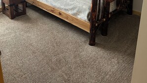 Ein Stockbett mit Holzrahmen und einem Deckenventilator.
