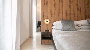 A modern bedroom with a wooden headboard, a bedside table, and a lamp. - KALEA Guest House (Cefalù)