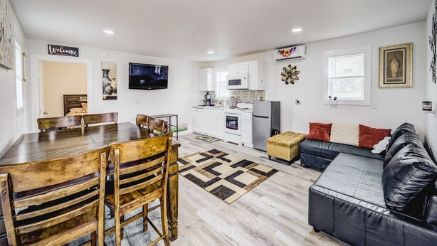 A modern apartment with a dining area, kitchen, and living room. - Cozy Tiny Homes Green (Rhome)