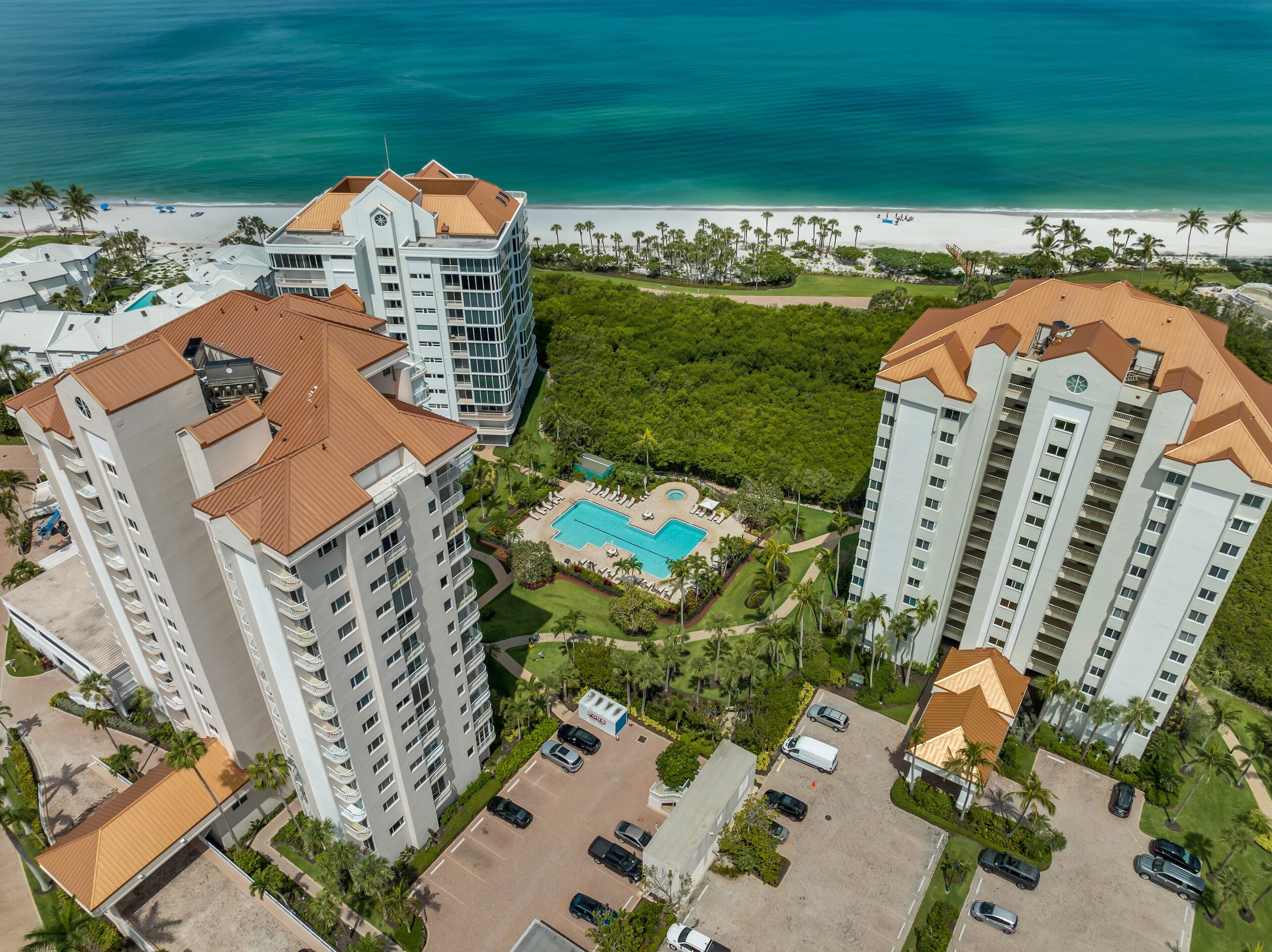 Un hôtel de grande hauteur doté de nombreux balcons, d’une piscine et offrant une vue sur la plage.