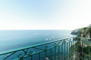 Une vue sur la côte, prise depuis un balcon doté d’une balustrade, avec la mer et les falaises en contrebas.