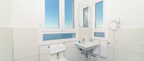 A modern bathroom with a bidet, a sink, and a mirror.