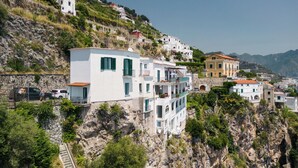 Un pueblo costero con edificios construidos en una ladera, con balcones y terrazas.