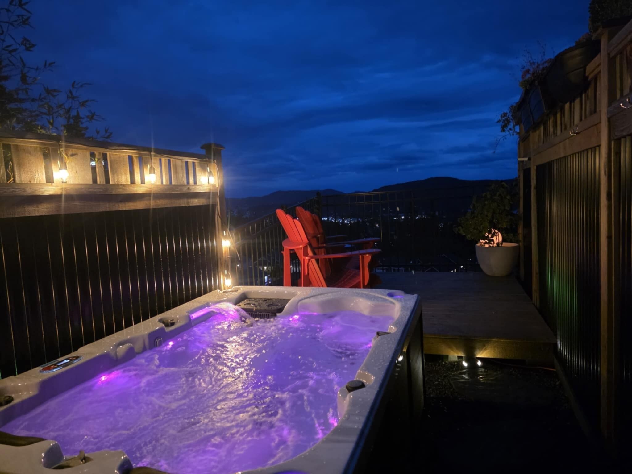 A hot tub with a view of the mountains at dusk.