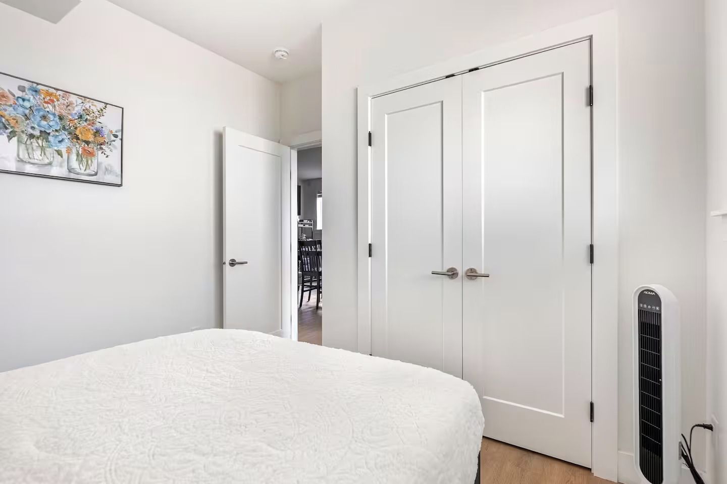 A bedroom with a bed, a white door, and a radiator.